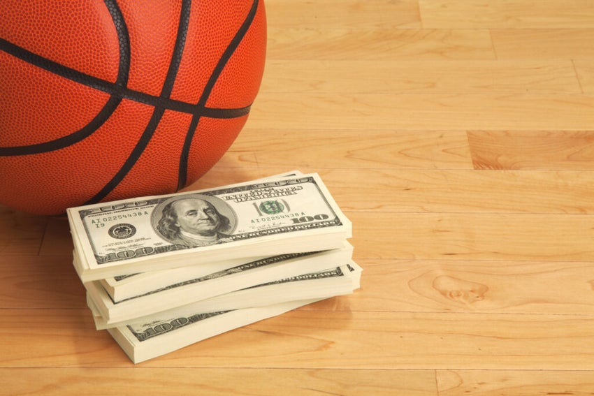 Basketball,And,Stack,Of,One,Hundred,Dollar,Bills,On,Wooden