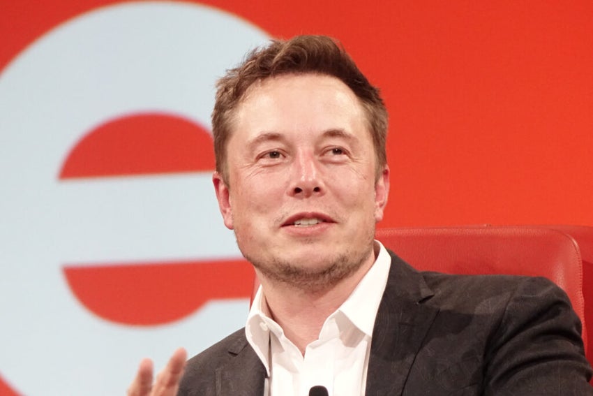 elon musk in front of an orange and white background
