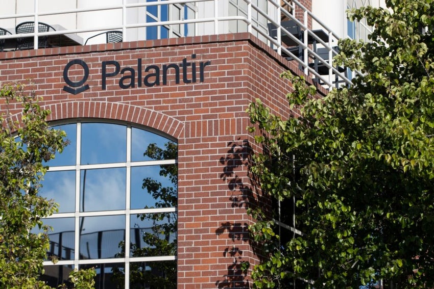 A brick office building featuring the Palantir logo in black on the front.
