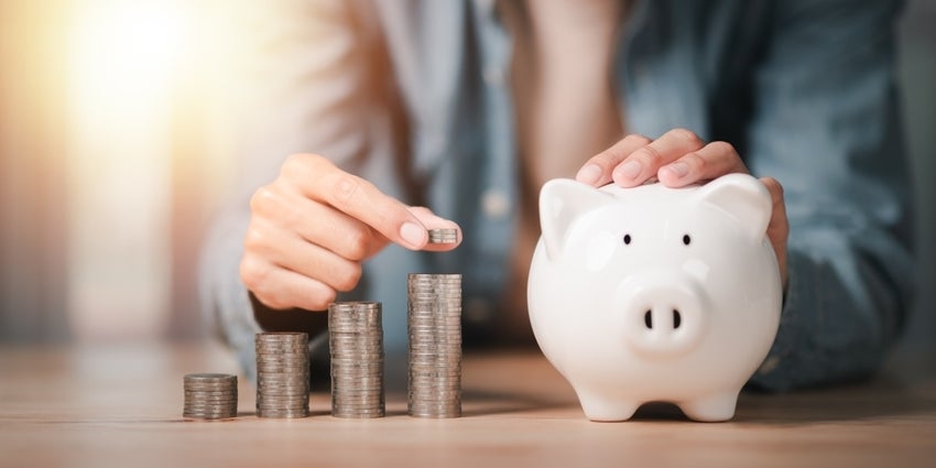 man filling piggy bank with coins to build wealth