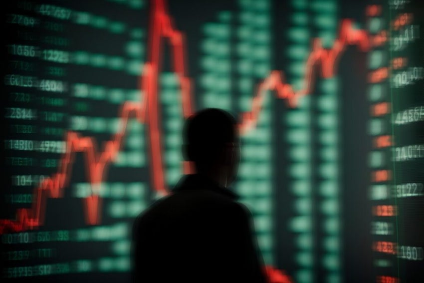 silhouette in front of trading chart