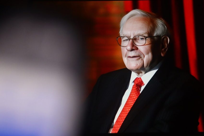 Warren Buffett in a suit with a red tie.