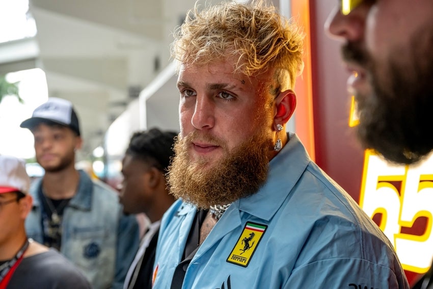 Jake Paul in blue shirt with Ferrari logo.