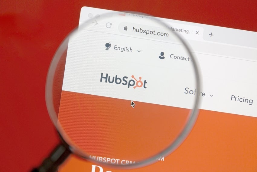 Magnifying glass over HubSpot website homepage.