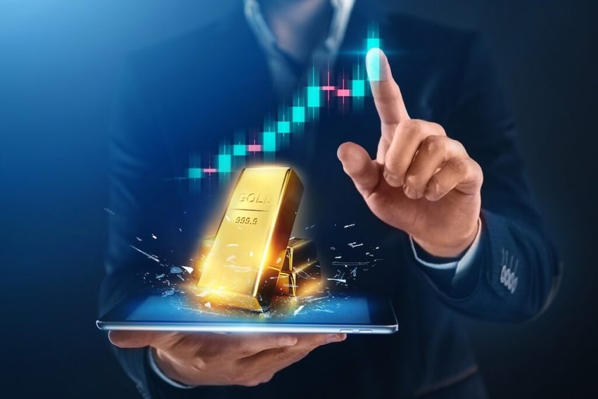 Gold bars and finanical chart up with man's finger pointing to the top