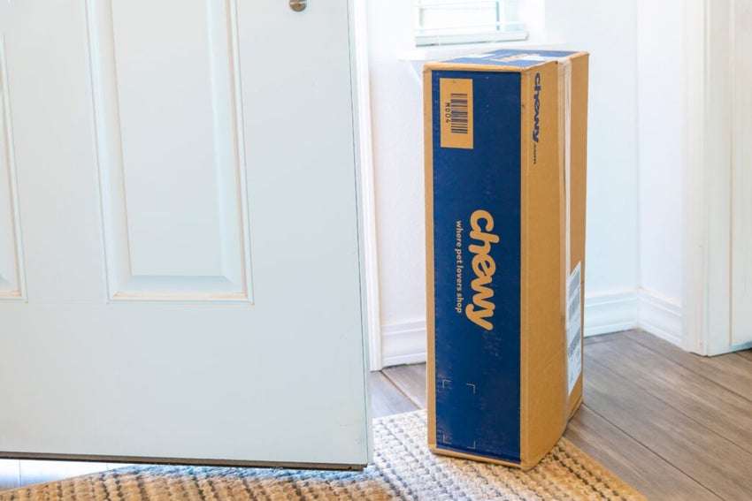 Chewy package near open door on floor.