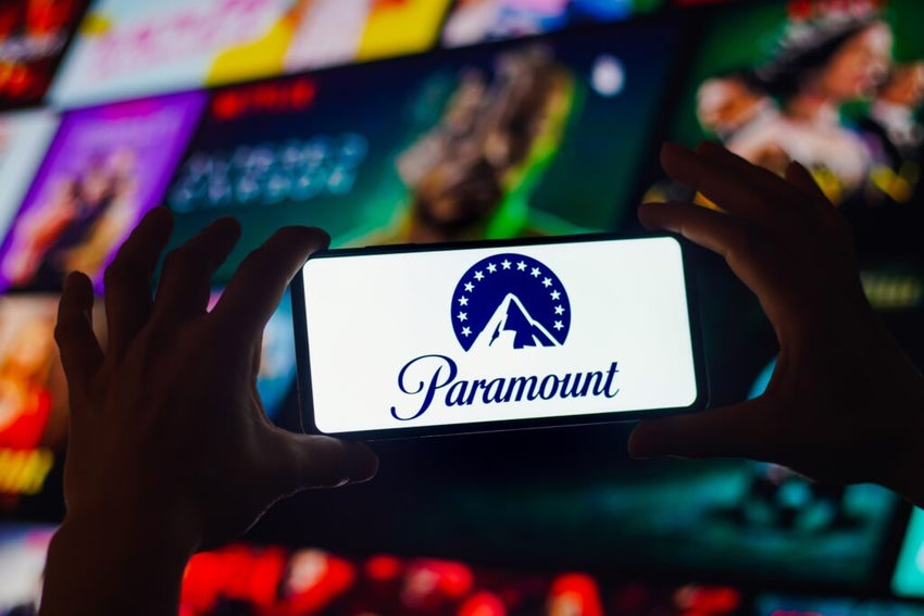 Hands holding phone with Paramount logo colorful background