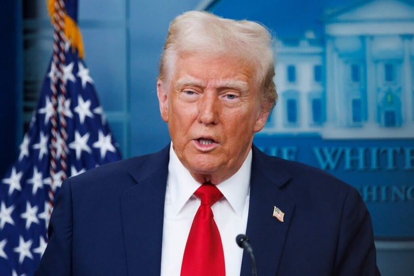 Donald Trump speaking at podium American flag background.