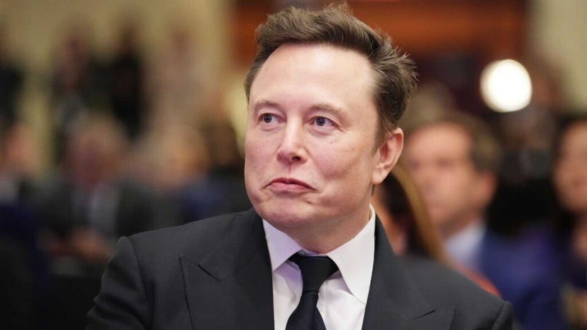 Elon Musk with people in the background