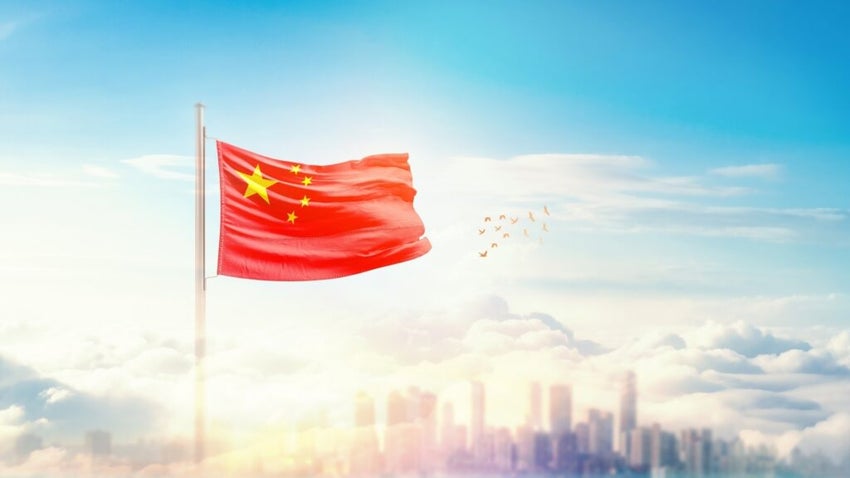 Chinese flag flying above clouds city skyline below