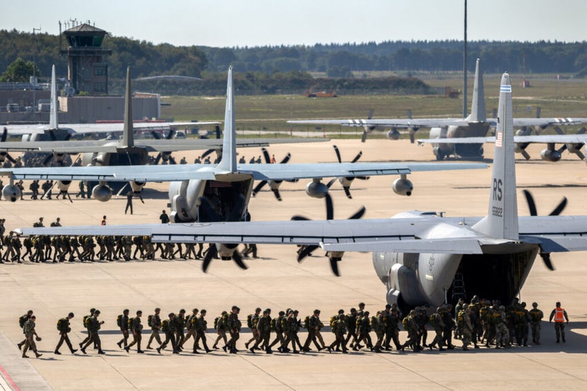 Soldiers boarding military aircraft on tarmac.