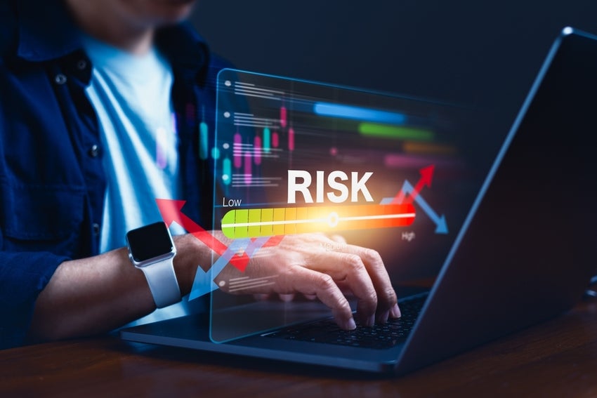 Person typing on laptop with risk gauge overlay.