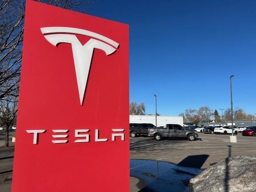 Tesla logo on a red board outside a Tesla facility