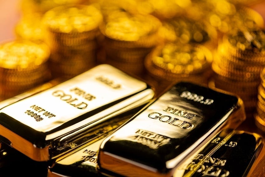 Gold bars and coins stacked closely together.