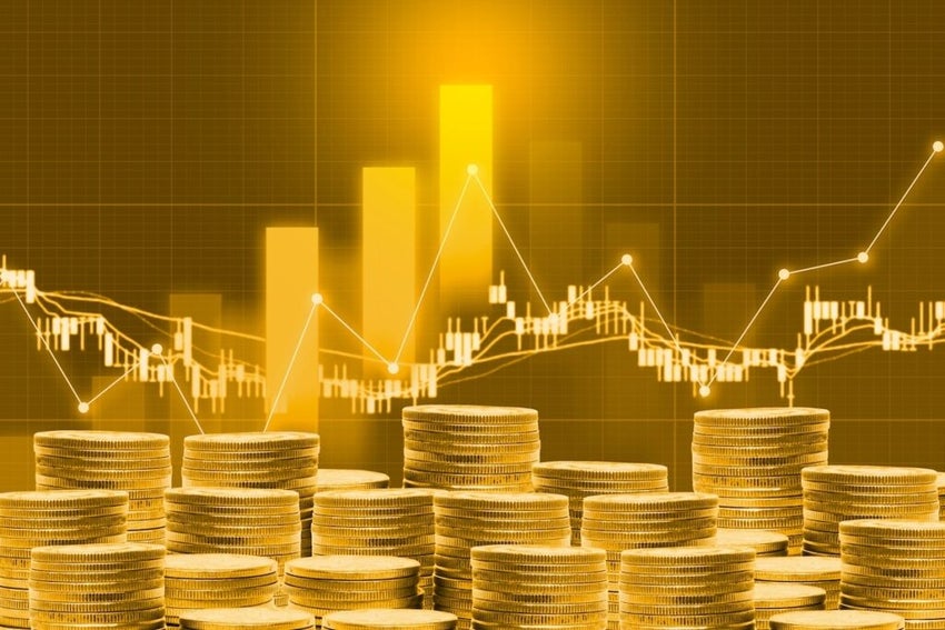 Stack of coins against stock market charts