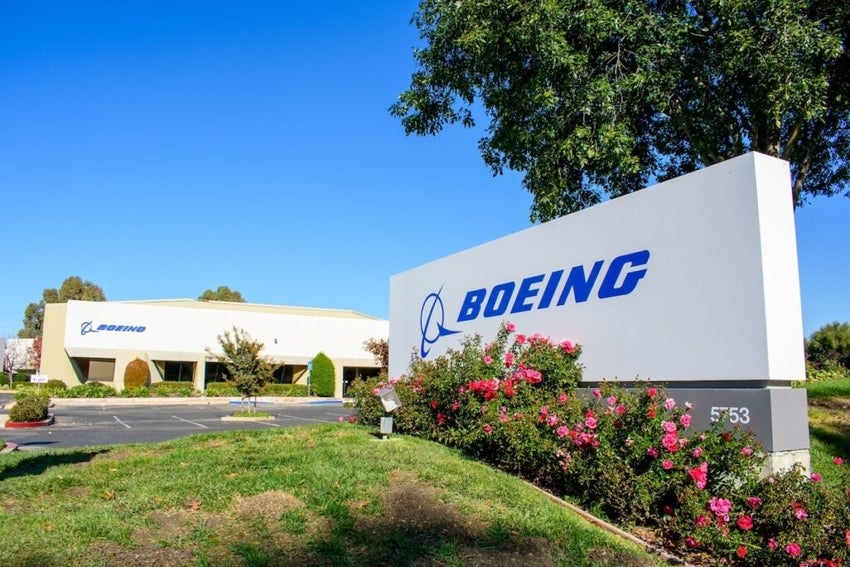 Boeing signage outside building with trees and flowers