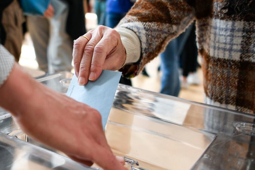 ballot paper in its envelope, held in the hand by a lady