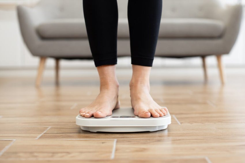Womens feet on scale to weigh herself