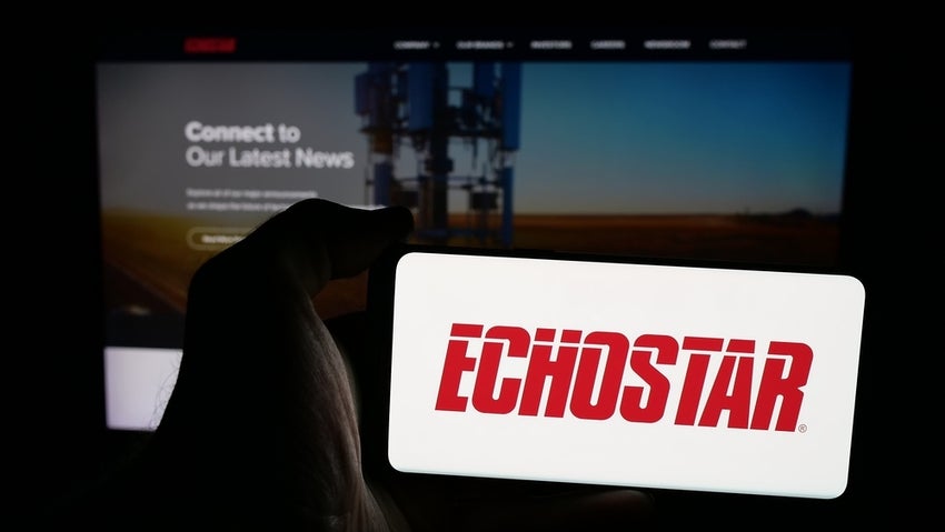 Person holding mobile phone with logo of EchoStar Corporation on screen in front of web page