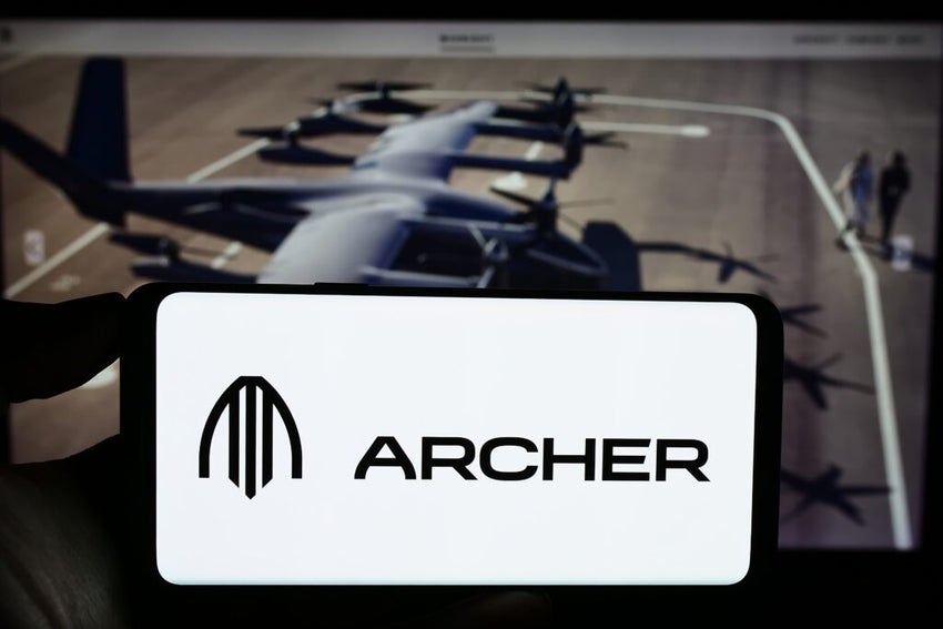 Person holding cellphone with logo of American eVTOL aircraft company Archer Aviation Inc. on screen in front of webpage