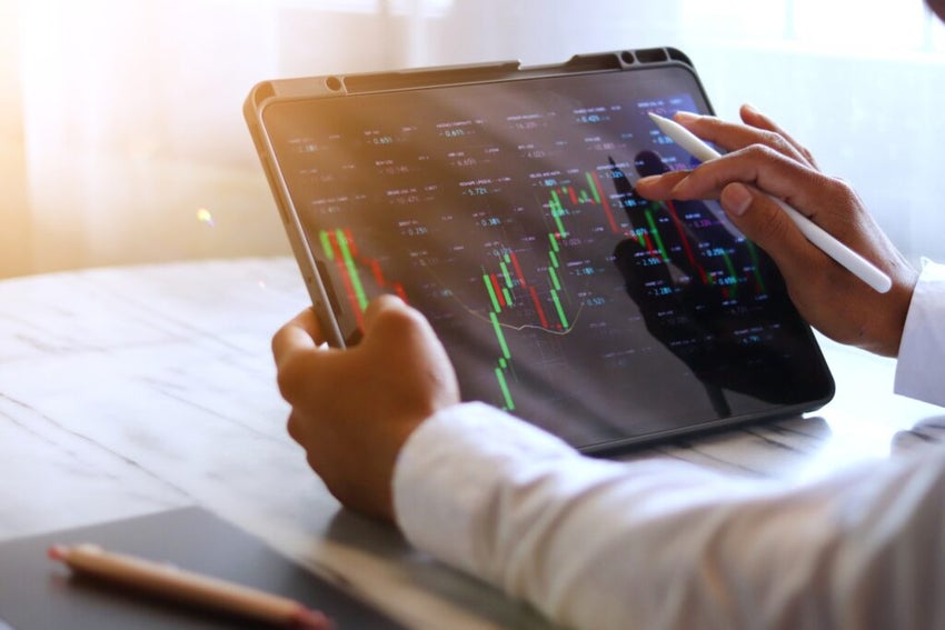 stock chart on tablet being held by hands