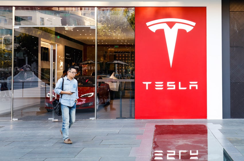 Person outside Tesla showroom.