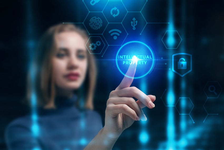 Woman working on a virtual screen of the future and sees the inscription: Intellectual property