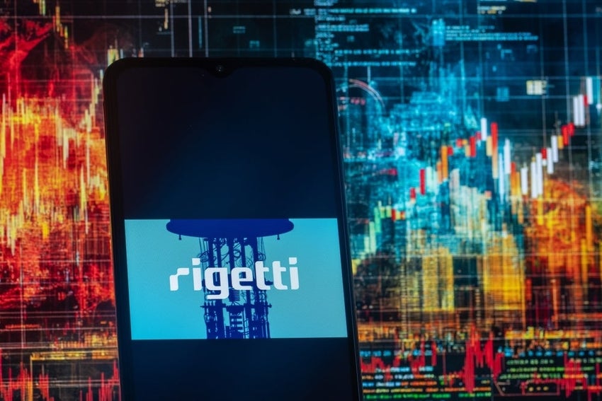 Rigetti Computing Inc logo on phone with stock market activity in background