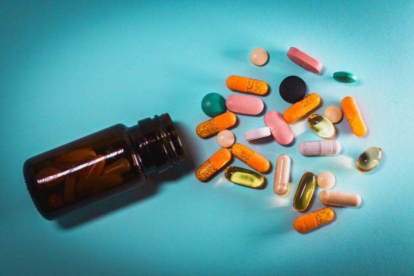 pill bottle and pills on blue background
