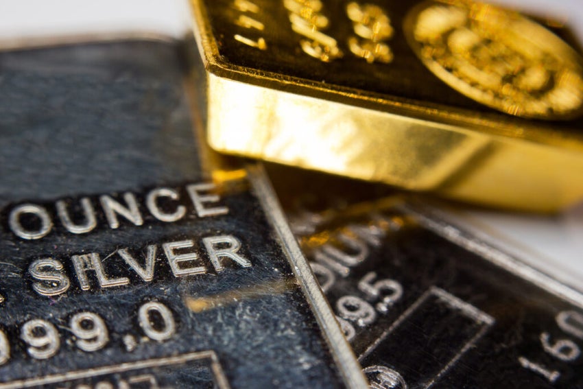 Gold bar lays on top of a silver bar