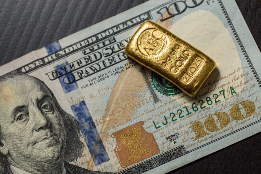 Gold bar on hundred-dollar bill close-up