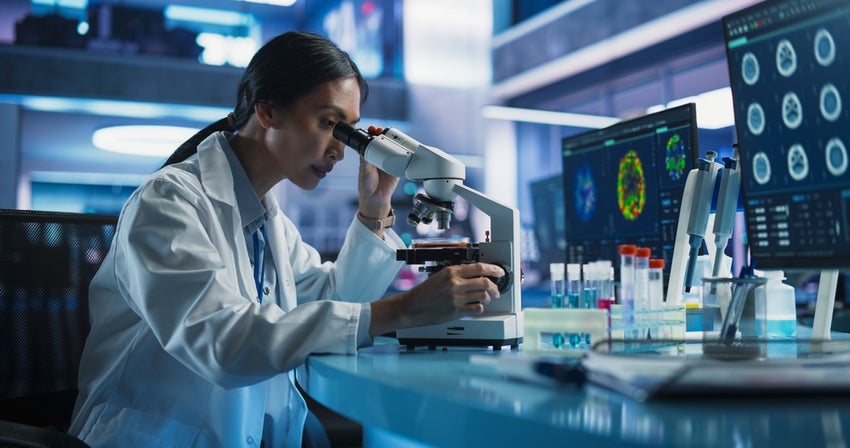 Scientist using microscope in modern laboratory.