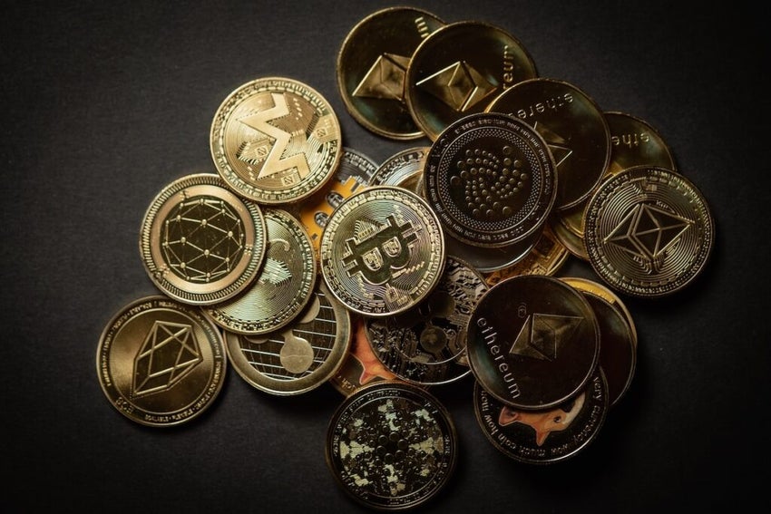 Close up shot of a golden Bitcoin in a stack, among other various digital cryptocurrencies