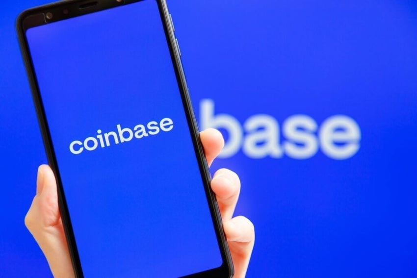 Smartphone displaying Coinbase logo blue background.