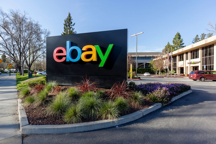 eBay sign outside of office with trees and blue sky.
