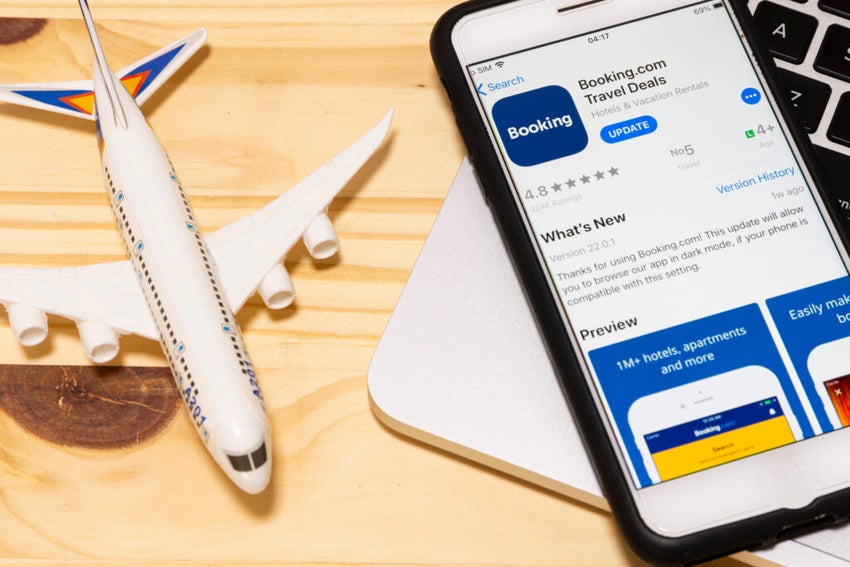 Toy airplane next to smartphone with Booking.com app