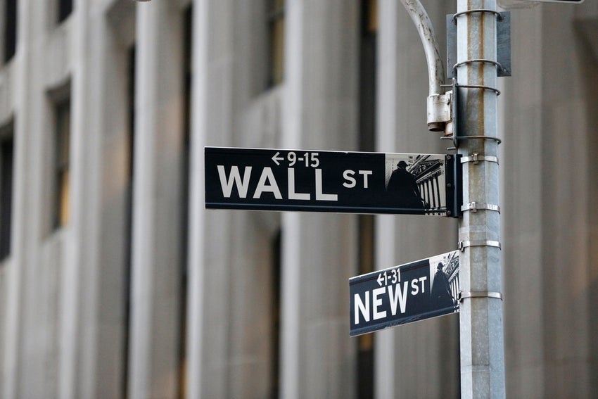 Wall St written on a sign post