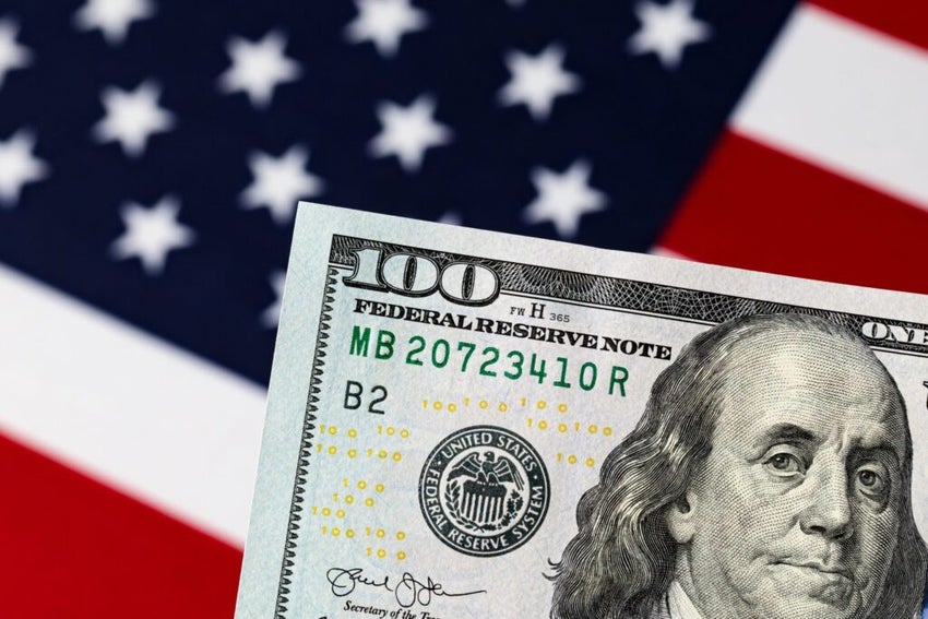 Dollar bill positioned in front of U.S. flag