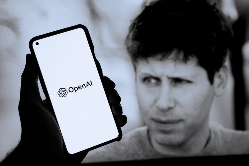 OpenAI logo on a phone with Sam Altman in the background