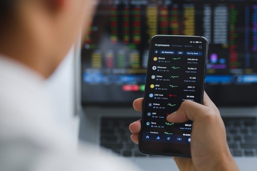 Close up of smartphone of young Asian investor watching the change of cryptocurrency market price.