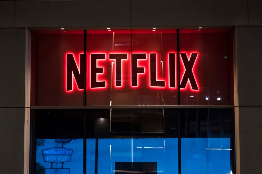 Neon Netflix sign on a glass building.