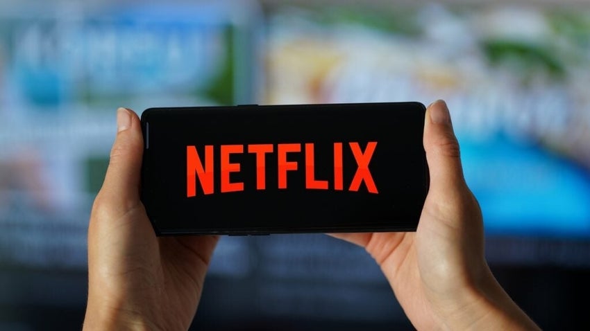 Person holding smartphone with Netflix logo