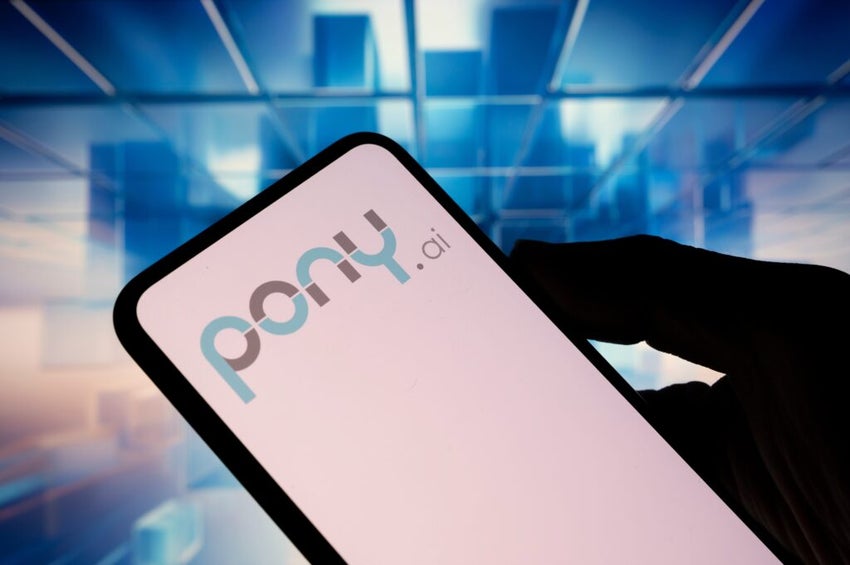 The logo of Pony AI, a Chinese autonomous vehicle company, appears on a smartphone screen with an abstract blue illustration in the background.