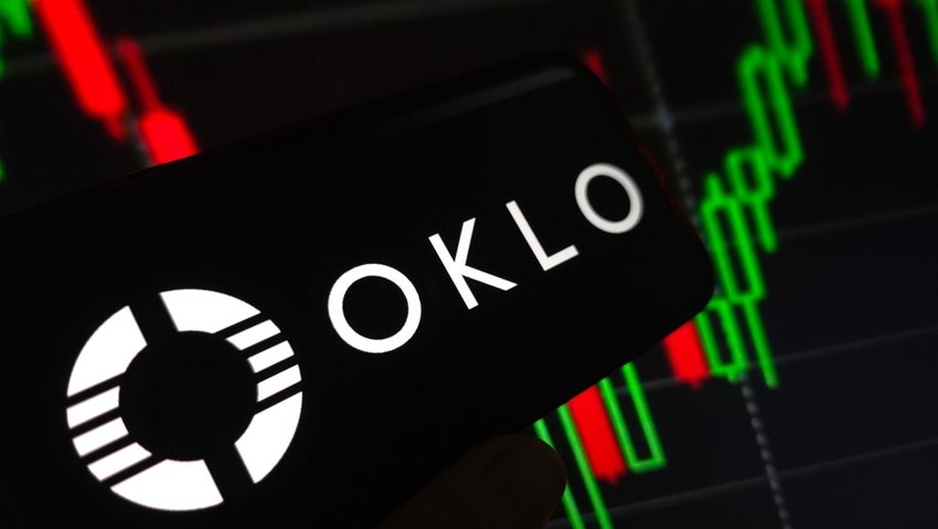 Oklo company logo displayed on mobile phone with stocks moving in background