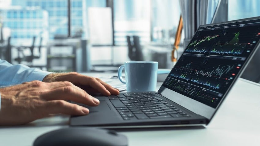Close-Up On Hands Of Professional Financial Analyst Using Laptop Computer With Stock Options Graphs And Charts On Screen. Man Analyzing Stock Market Data And Enjoying Coffee In Hedge Fund Office.