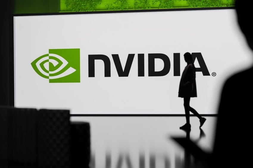 Silhouette of person walking past NVIDIA logo.